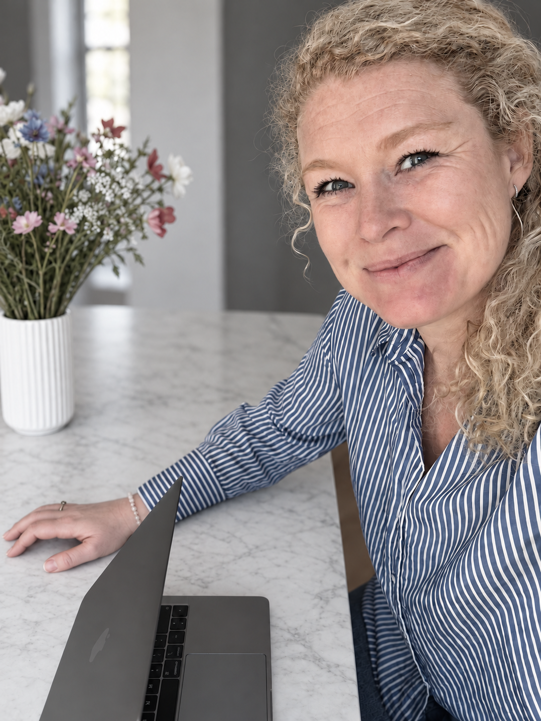 Anja Sindberg ved et bord med sin computer